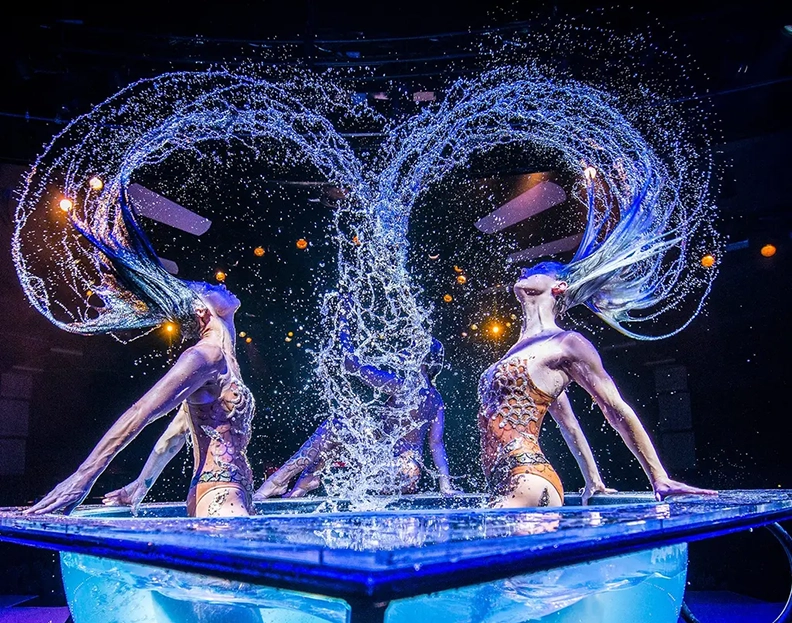two women plunging out of the water with their long hair creating swirls from the water