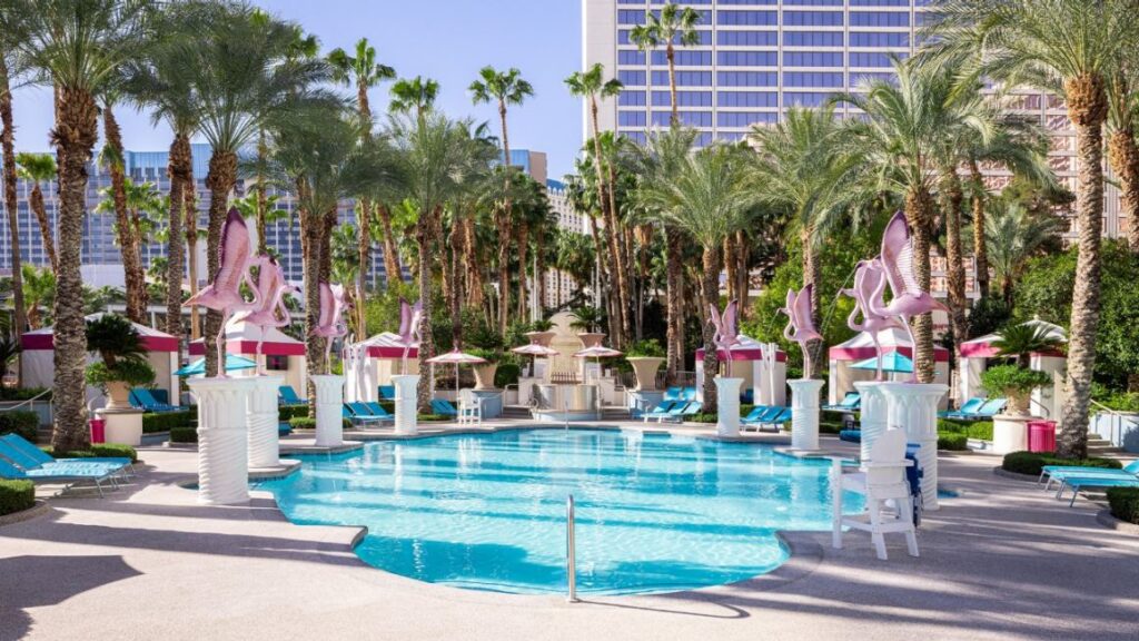 A swimming pool surronded by palm trees 