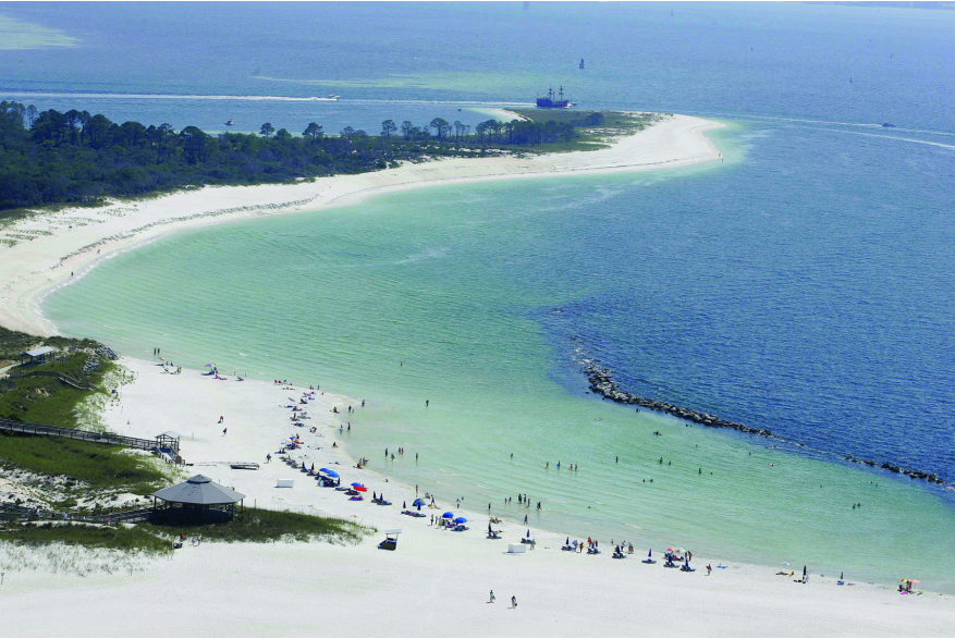 white sandy beach in the foreground with flate calm ocean in the background 