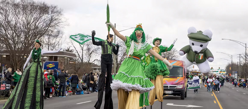 Pary goers dressed in green parading down the street for St. Patrick's Day Parade