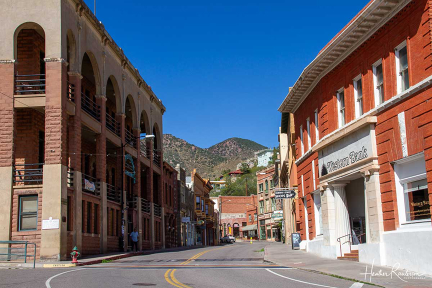 a city street down the center of historic Bisbee buildings 