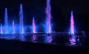 Fountains illuminated in blue and purple at night 