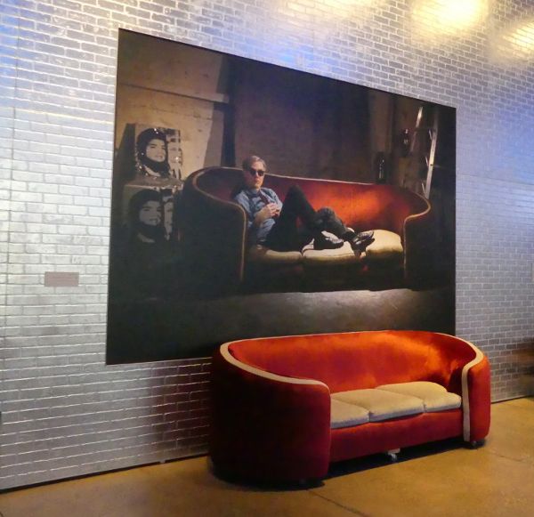 Large portrait on the wall behind a red sofa