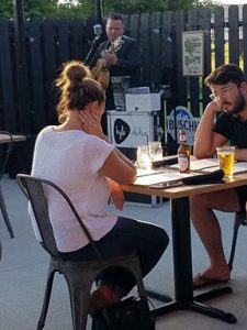 People seated eating outside at Oak & Barrel