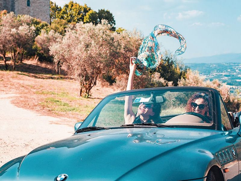 Tow people driving in a convertible