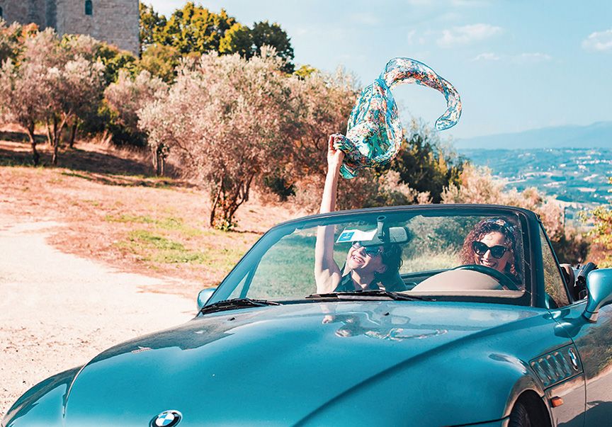 Tow people driving in a convertible