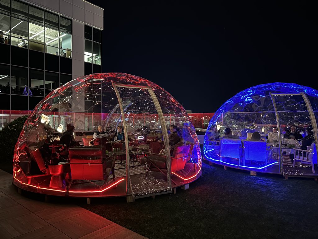 A red igloo and red igloo for dining located on the Juniper rooftop. 