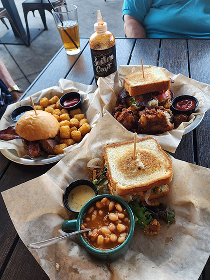 3 bbq meals with baked beans on wooden table 