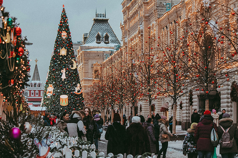 city street winter scene with tall christmas tree and church steeple in background