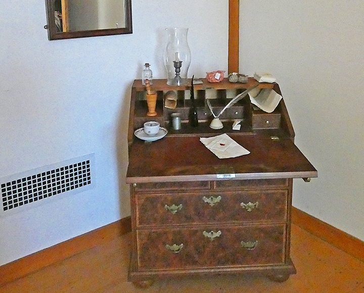 An antique roll-top desk with the cover pulled open