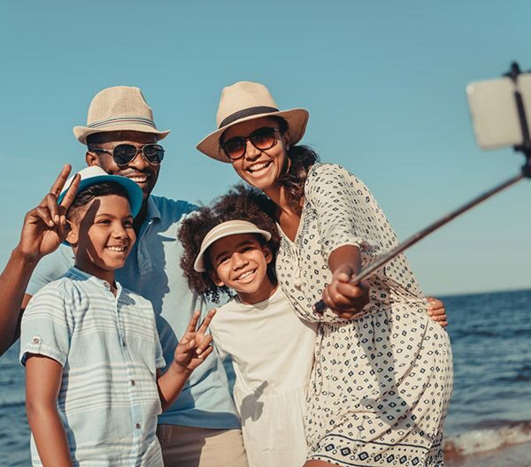 Family of four taking a selfie on the beach