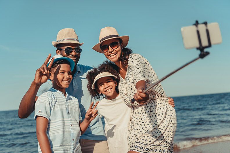 Family of four taking a selfie on the beach