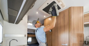 Someone  tending to AC fan inside RV