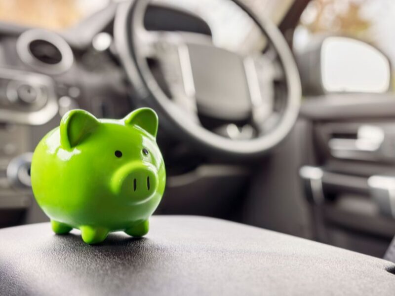 Green piggy bank inside a car