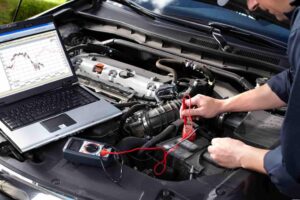 Mechanic checking under the hood of a car checking the battery