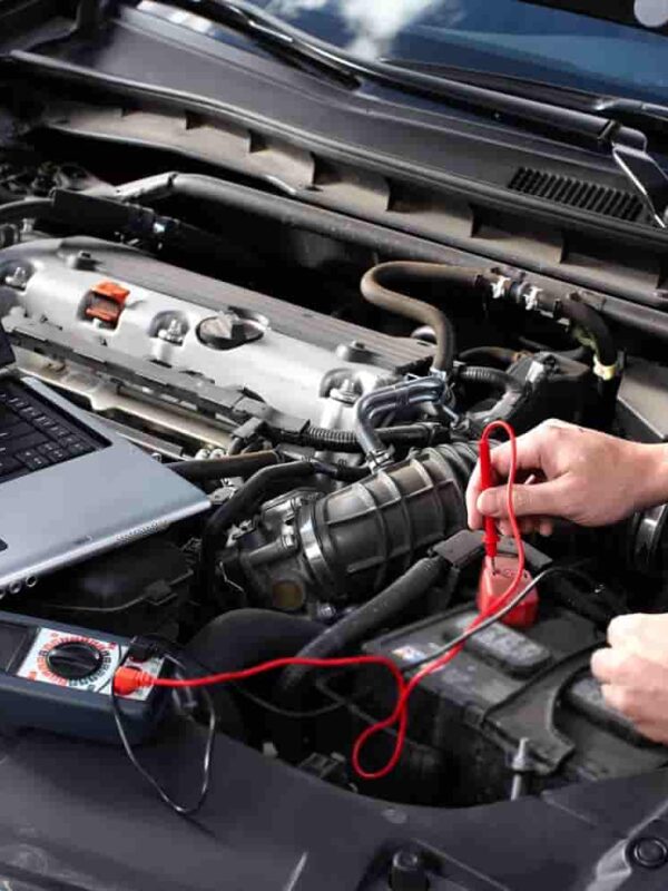 Mechanic checking under the hood of a car checking the battery