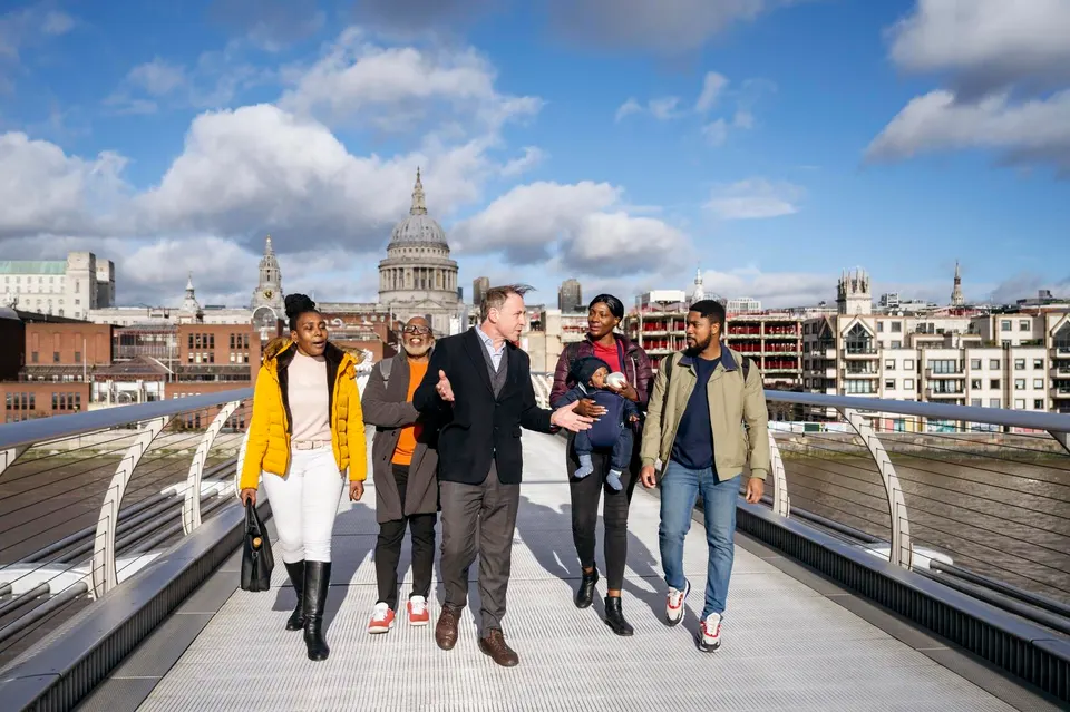Tour guide walking across a bridge showing a goup his city
