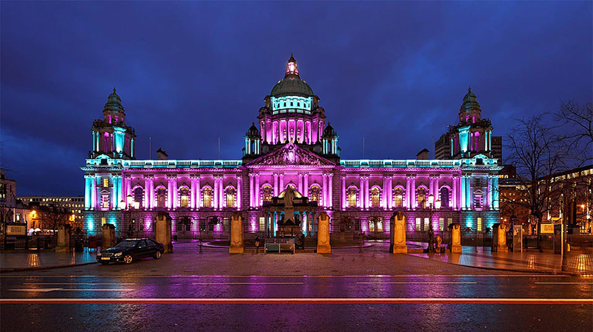 outside view of the Belfast city hall at night with purple glowing lights