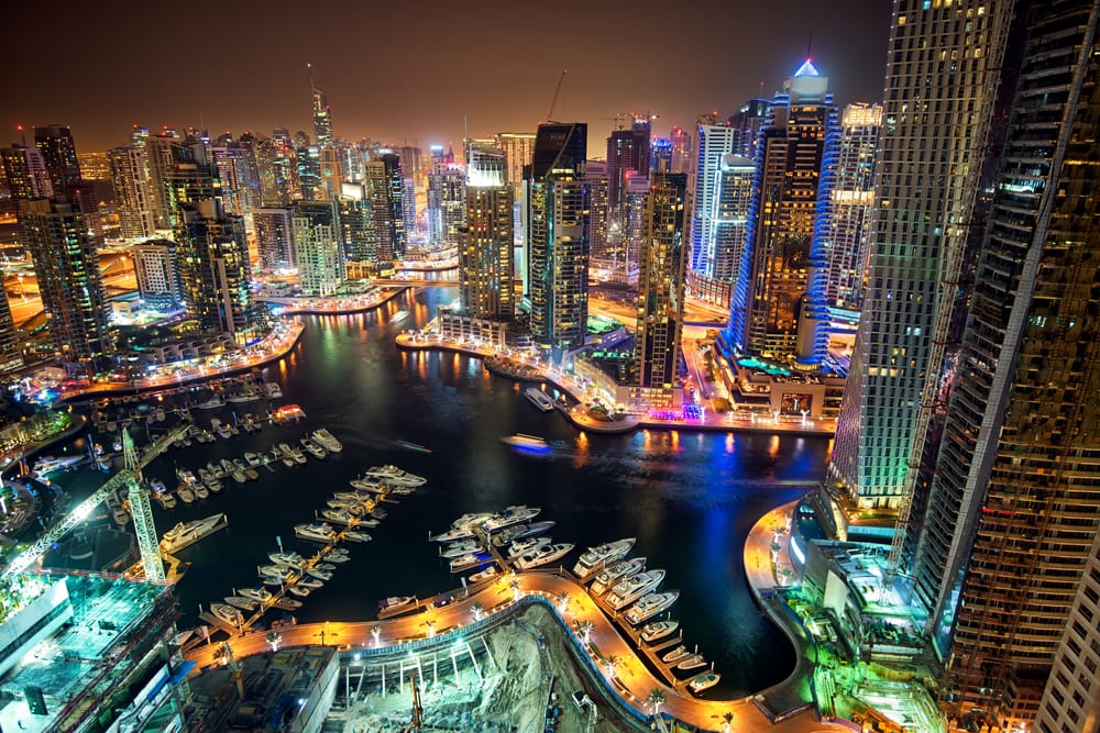 Nightime aerial view of Dubai with street lights glowing