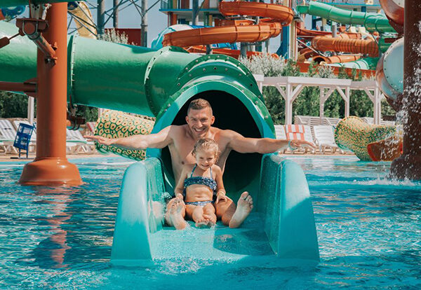 Father and daughter going down waterslide