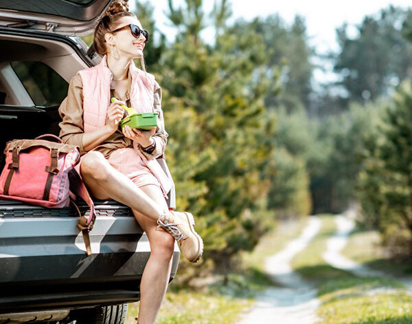 Lady sitting in back of car eating a snack