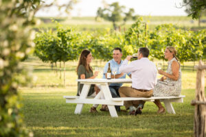 People sitting at a white picnic table at a Hill Country winery