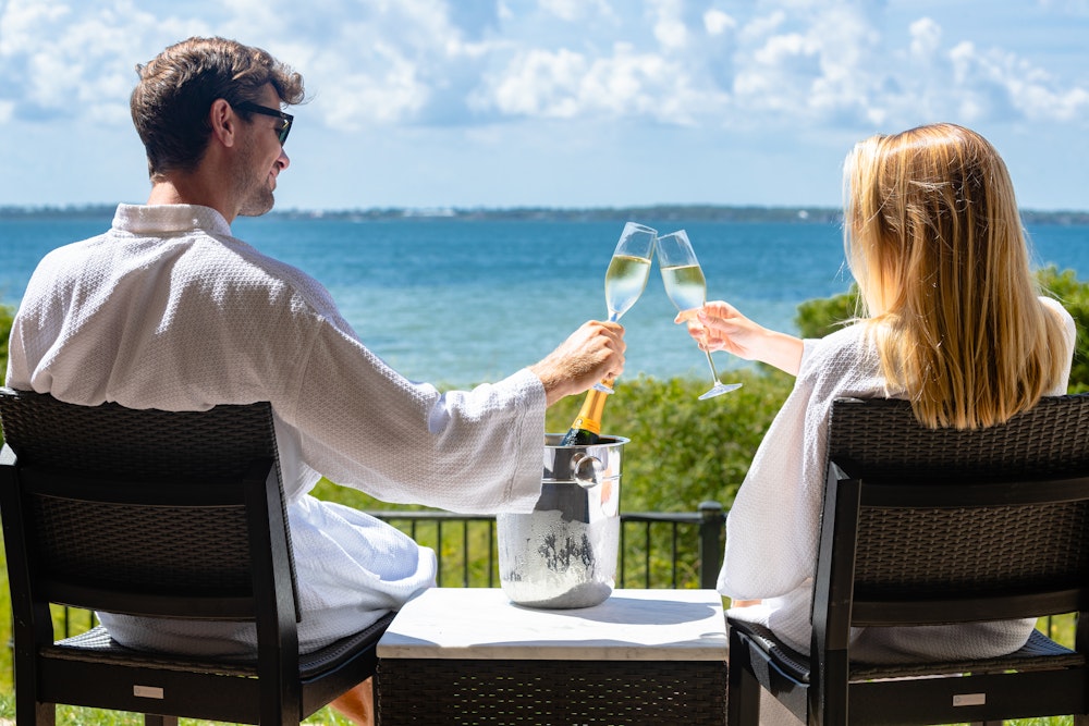 A couple enjoying a drink together in front of a beach