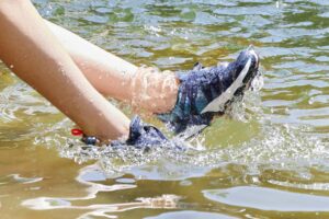 close up view of someone's water shoes in the water 