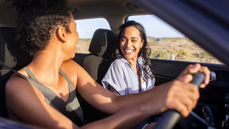 Someone driving in a car with a friend on a road trip