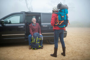 Family outside a van with hiking/camping gear