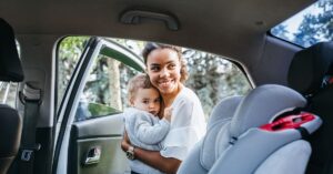 Mother putting baby in the car