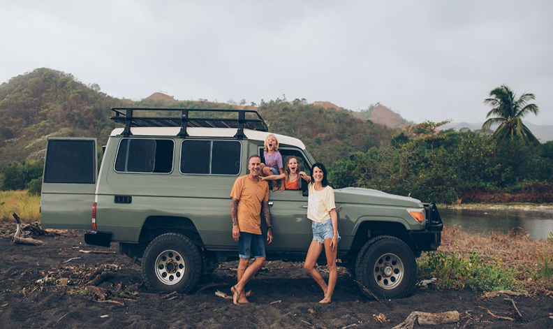 Family standing by their car
