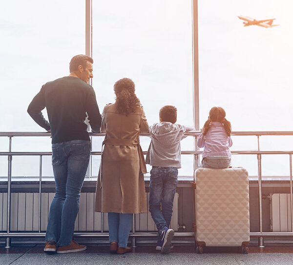 Family lined up looking out of an airport window