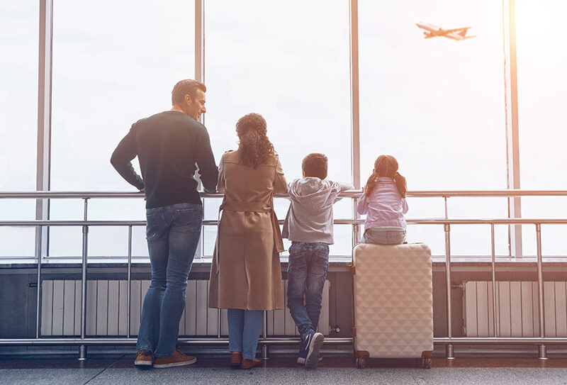 Family lined up looking out of an airport window