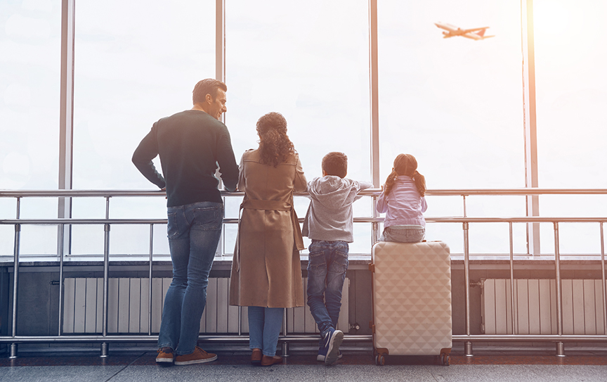 Family lined up looking out of an airport window