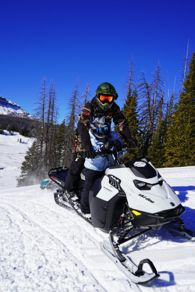 man steering downhill on a white snowboard