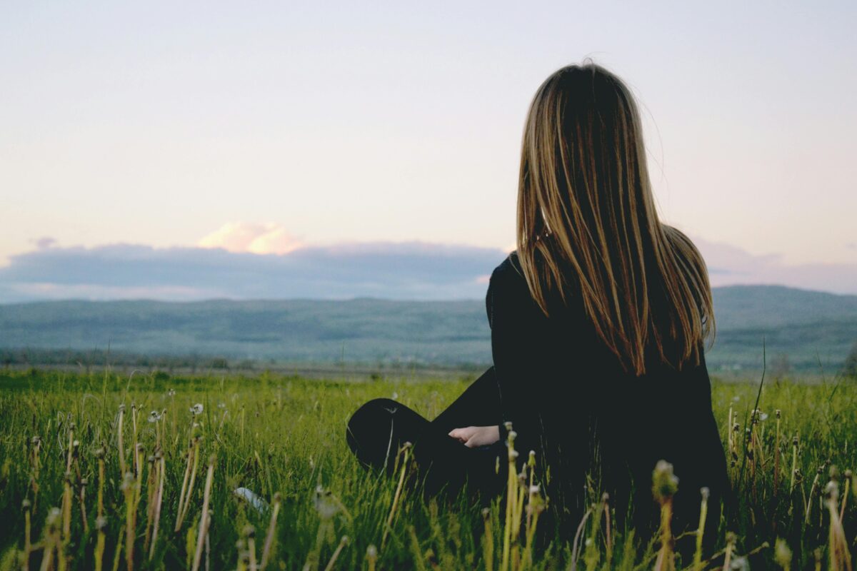 Someone sitting in the grass. Relaxing and enjoying the outdoors.