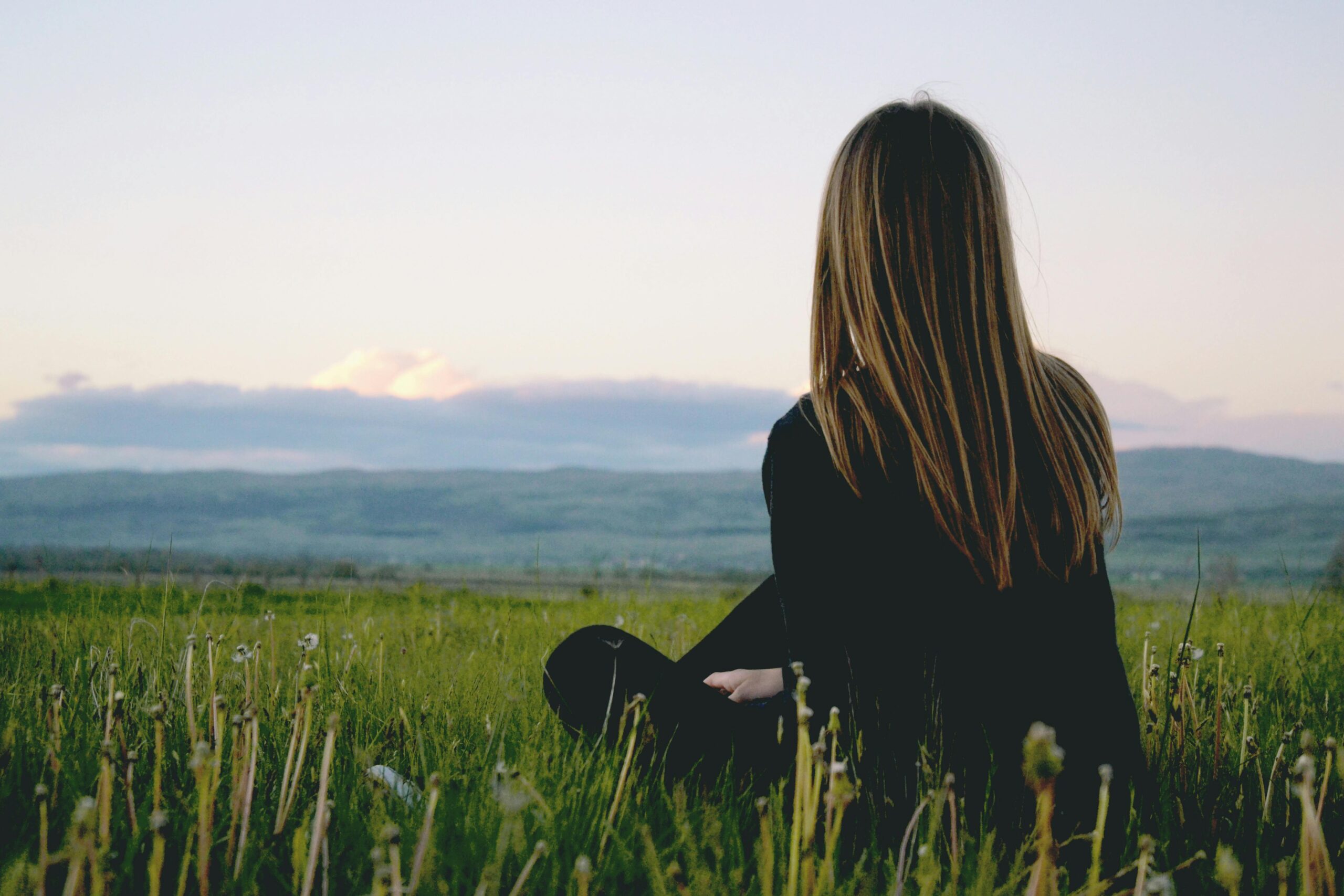 Someone sitting in the grass. Relaxing and enjoying the outdoors.