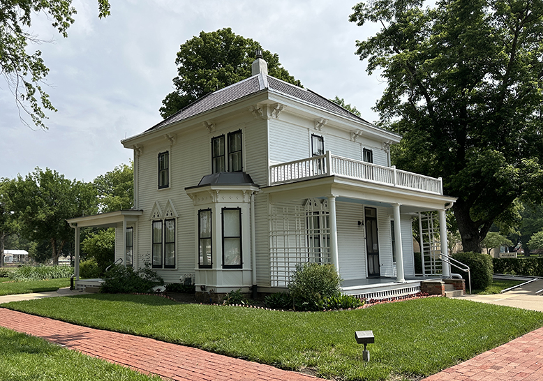 two-story white house with front porch across the front. 
