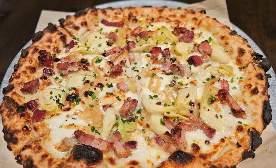 Huge full plate of a pizza topped with pineapple chunks and ham