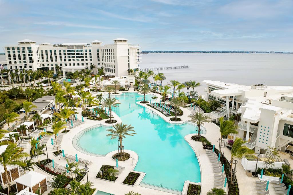 Aerial view of rounded swimming pool in center of city buildings 