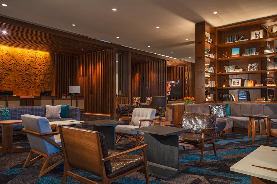 dark brown wood decorated hotel lobby with tables and chairs