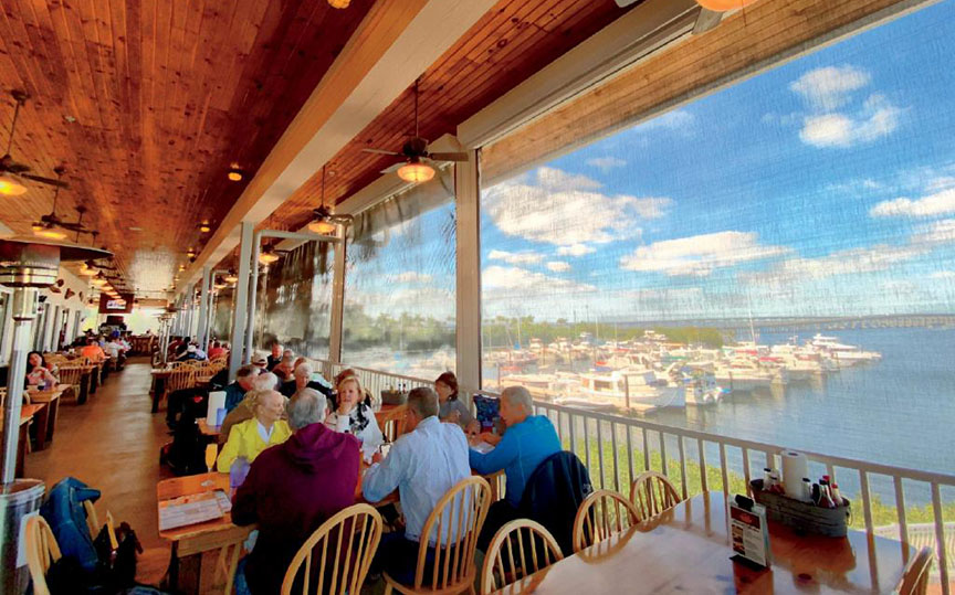 Dining in a restauran with a large window overview of the ocean and beach 