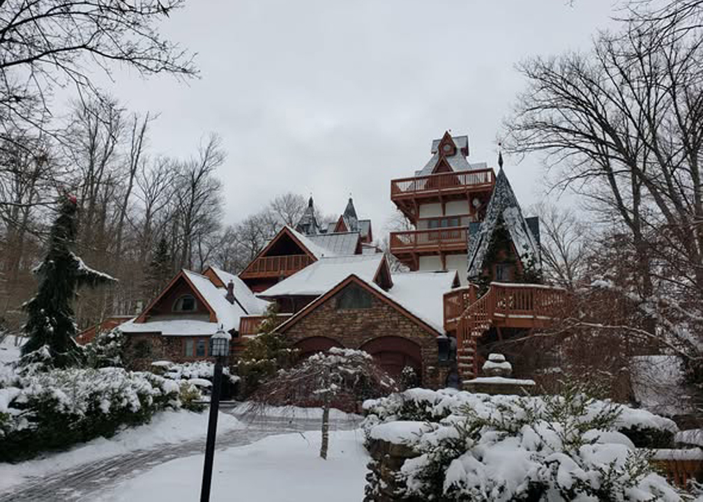 a brown lodge with several pointed peaks in roof cofereed with a light dusting of snow 