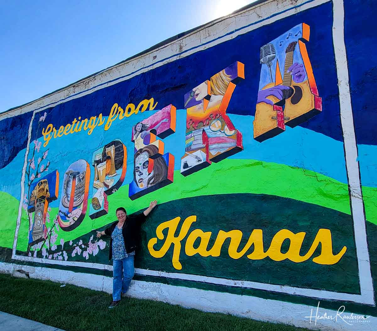 a billboard sign of kansas with city pictures embedded in the letters of the work KANSAS