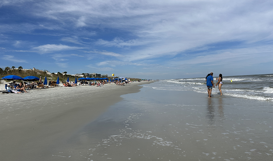 a couple walking along the beach near ocean