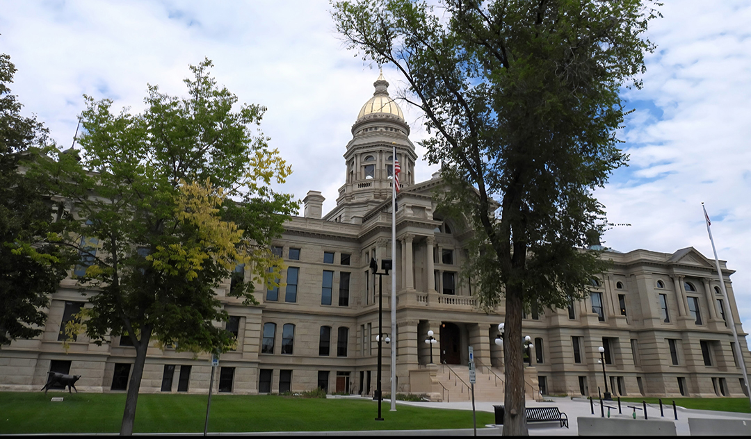 the exterior view of the wyoming capitol building among trees