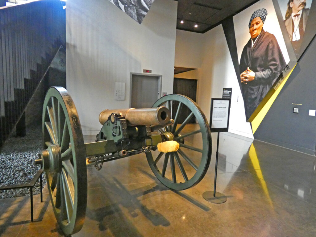 An antique cannon sitting in a room with wooden floor