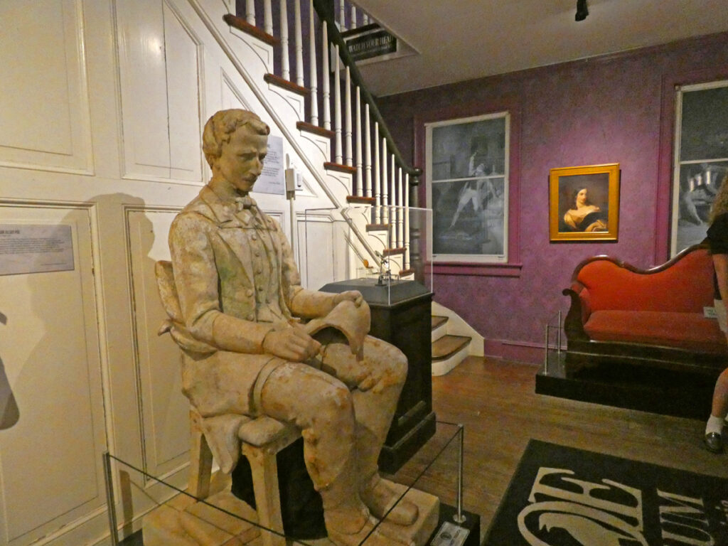 statue of a person sitting in front of a stairway 