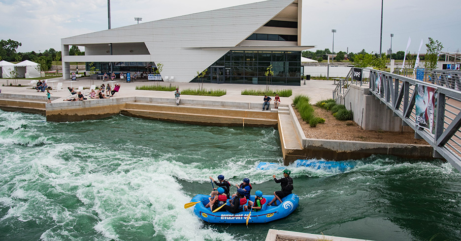 a round raft with people in water near the railing